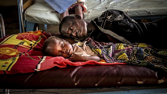 Obrázok Na fotke je africký chlapec Pierre s otcom. Vo veku 3,5 roka vážil len deväť kíl, pred smrťou ho zachránili v poslednej chvíli